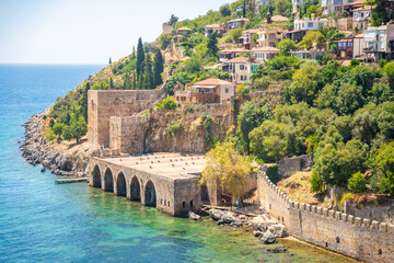 Naklejka premium Ancient shipyard or Tersane near of Kizil Kule tower and beautiful beach and calm turquoise sea surface in Alanya, Turkey