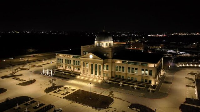 Aerial view of Denton Texas courthouse illuminated by lights at night. Slowly orbiting