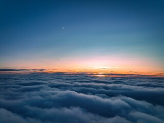 Breathtaking view of a sunset, with an orange and pink sky filled with fluffy white clouds