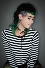 Young Caucasian woman with bright green hair sitting with closed eyes