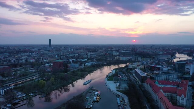 Wroclaw sunset at Odra river aerial follow shot with a passenger ship.