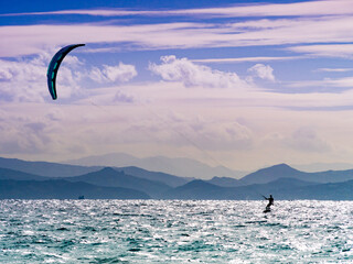 Kite surfer riding waves. Kiteboarding sport.