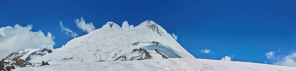 Fototapeta na wymiar Panorama of a mountain range in the Caucasus mountains. Mount Elbrus.