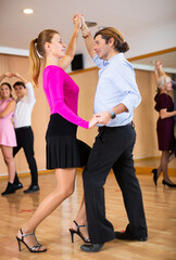 Fototapeta premium Couple of dancers rehearsing ballroom dances in dance studio