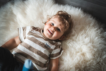 Kind hat Spaß auf Schafsfell und lacht