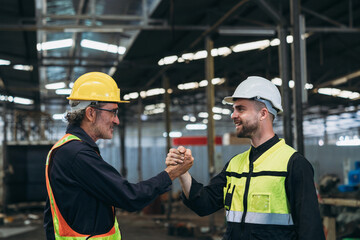 Team Engineer is shaking hands. Industrial worker in the factory. Engineer is maintaining in the warehouse.