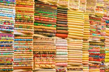 Colorful textile materials organized in Dubai market.