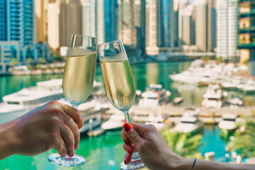 A young couple toasts with champagne in Dubai at the Marina Promenade.