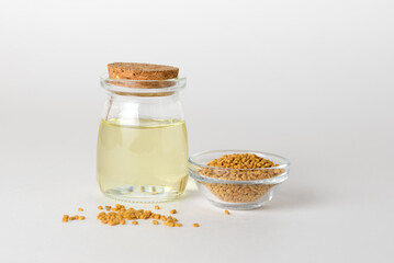 Fenugreek essential oil in glass container  and fenugreek seeds isolated with copy space
