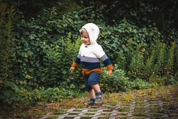 Fotobehang Kind rennt lachend im Garten herum © Maria