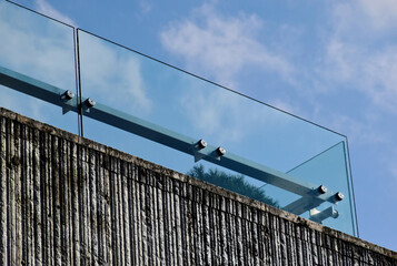 clear glass balustrade railing. laminated tempered safety glass. concrete exterior wall. roof...