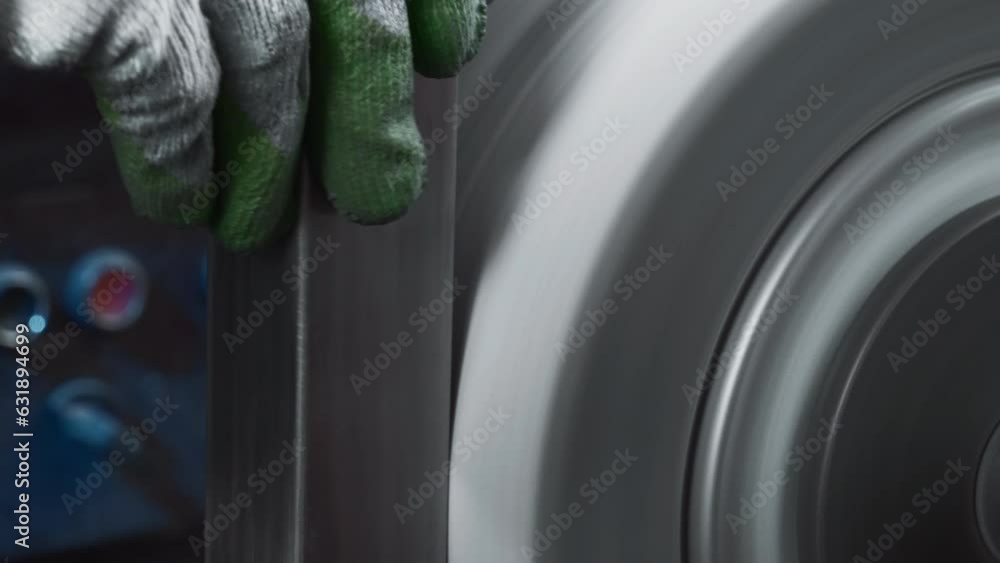 Poster close-up polishing of steel part on rotating machine. creative. rectangular steel part is polished o