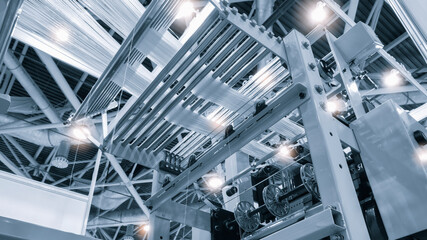 synthetic textile thread,  thread at industrial weaving manufacturing machine,  textile fabric production industrial machinery concept background