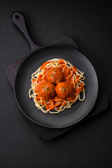 Delicious fresh meatballs and pasta in tomato sauce with salt, spices and herbs