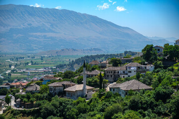 green hills and mountains with small houses and a mosque in gjirokaster albania. the shot was taken from the castle.