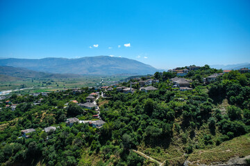 green hills and mountains with small houses in gjirokaster albania. the shot was taken from the castle.