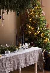 Festive table on the background of the Christmas tree. Decorations and decor for the New Year