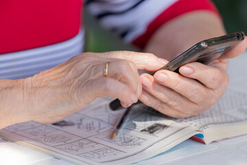 close-up of elderly woman's hands typing on mobile phone