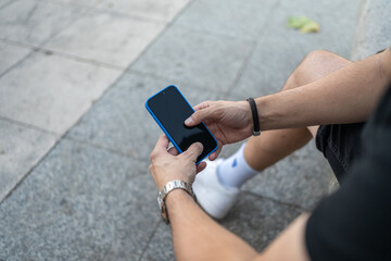 Close-up image of unrecognizable young man's hands using his smartphone.