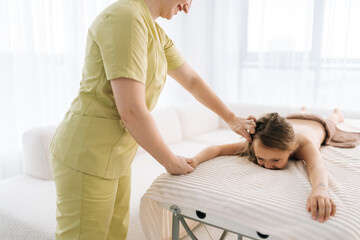 Cropped shot of unrecognizable female pediatric masseuse doing therapeutic massage to relax...