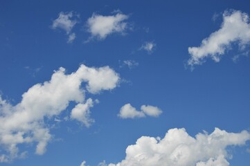 Fototapeta na wymiar White voluminous clouds against a bright clear blue sky on a clear day.