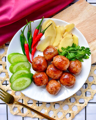 Isaan sausages on a white plate With cucumber, chilli, ginger and coriander ,top view ,Thai call sai krok isan - obrazy, fototapety, plakaty