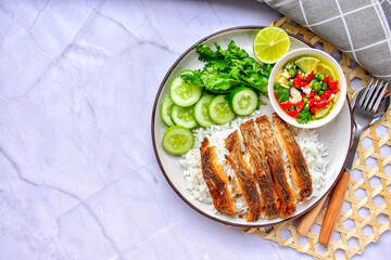 Fried fish rice with chili fish sauce With cucumber, coriander,lemon , top view on the marble background , Thai style street food, copy space