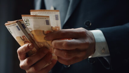 Closeup hands counting money denomination of fifty euro. Man calculating cash.