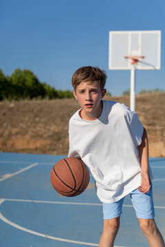 Young boy playing basketball outdoors. Sports concept.