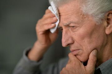 Close-up portrait of sad senior man with headache