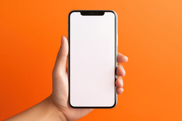 Close-up of woman's hand on orange wall. Showing empty white screen of modern smartphone. Businesswoman unlocking it with fingerprint.