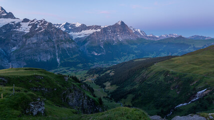 View on the Eiger Nordwand and other famous Swiss Alpine mountains during sunrise on a summer morning, as seen from the mountain hut First on First mountain. early morning sunrise in Switzerland.