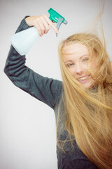 Female messy long hair holds spray bottle