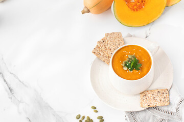 A mug of warm pumpkin soup. The concept of the autumn menu. Autumn recipes. Copy space