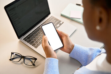Over shoulder view of African Black girl student holding mobile phone with white blank mock up cellular screen applications using cell phone. Cellphone display mock up for advertising apps concept.