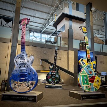 AUSTIN, TX, MAY 2023: giant Gibson electric guitar sculptures designed by different artists, part of Austin GuitarTown public arts project, on display at Austin–Bergstrom International Airport