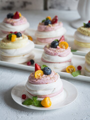 pavlova dessert with fruit close-up on a light background