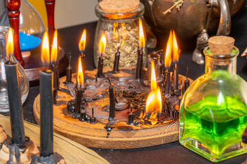 Fototapeta na wymiar Witchcraft composition selective focus with candles lights, magic items tools and symbols. Occult and esoteric concept. Mystic Halloween. Magic chemistry and witch craft.