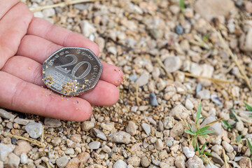 Finding a coin in a ground, treasure hunting concept