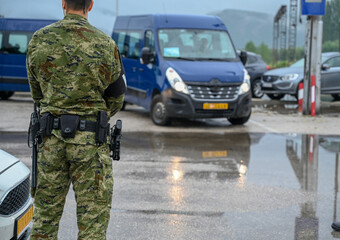 Military policeman in camouflage uniform. A policeman with a gun, a baton on his belt.