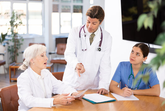three doctors communicate at daily meeting to confirm chosen therapy