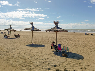 Fototapeta na wymiar A row of parasols for tourists on a peaceful sandy beach. Open sky. Sunny day.