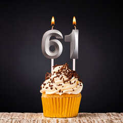birthday cupcake with number 61 candle - Celebration on dark background
