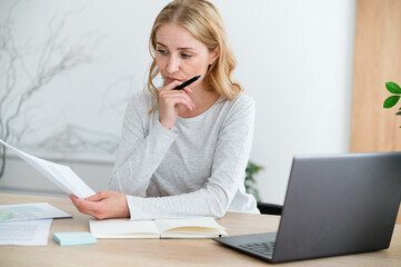 Pensive woman reading document, checking research, preparer report for work