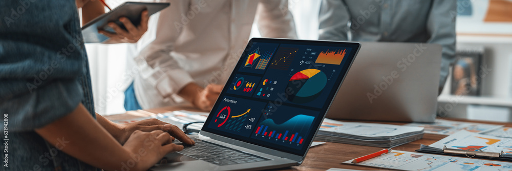 Leinwandbilder Panorama shot analyst team utilizing BI Fintech to analyze financial report with laptop. Businesspeople analyzing BI power dashboard displayed on laptop screen for business insight. Scrutinize