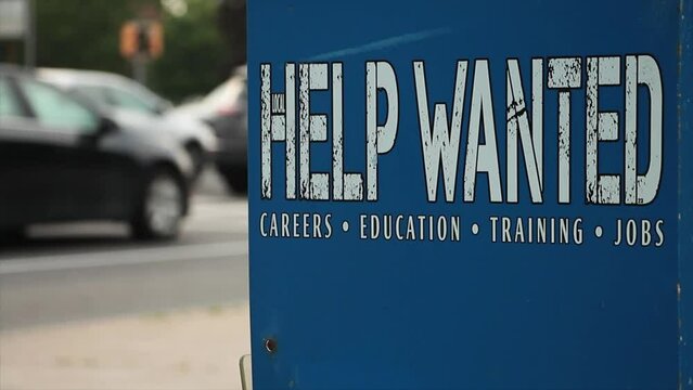 Help Wanted Careers Education Training Jobs Printed In White On Side Of Blue Newspaper Vending Machine Outside, Close Shot Top Right Frame With Vehicle Traffic Passing Frame Left