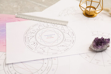 Zodiac wheels and natal charts for astrological predictions on table, closeup