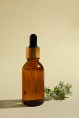 Fototapeta premium Bottle with cosmetic oil and flower on beige background