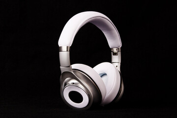 Stylish modern white headphones on black background.