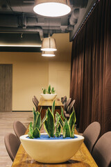 View of the room interior with a wood tables, chairs, brown curtains.